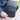 A person holds a dark gray Julbo Eyewear Woodsman Hat with a black brim and logo; this cold weather hat features side ear flaps folded up. #color_julbo-woodsman-hat-charcoal