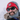A bearded man wearing a red Carhartt knit hat, Julbo-usa Montebianco 2 dark sunglasses with removable side shields, and winter clothing smiles outdoors in snowy weather.