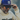 A man in Julbo Eyewear's Ward retro sunglasses, a blue cap, and a cream-colored sweater adjusts his hat with one hand.