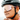 Close-up of a person adjusting the chin strap of Julbo-usa Density, a black bicycle helmet paired with large mirrored performance eyewear featuring a cylindrical lens.
