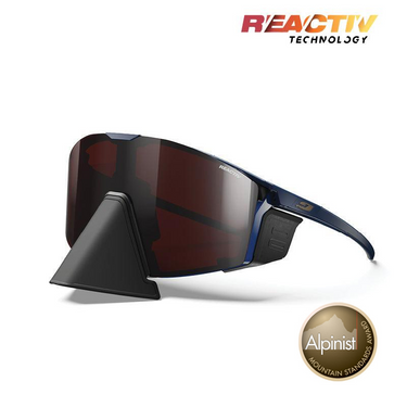Julbo Eyewear Edge Cover sports sunglasses with dark lenses, blue frame, and REACTIV Technology logo. Adjustable nosepiece for a custom fit. Alpinist Mountain Standards Award badge appears at the bottom right. #color_blue-blue-with-reactiv-0-4-high-contrast-lens