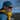 Wearing a teal cap, yellow jacket, and Julbo Eyewear's Explorer 2.0 RX sunglasses with REACTIV photochromic lenses, a man stands outdoors on a sunny day, gazing into the distance.