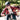 A person wearing a helmet and Julbo-usa Fury S Kids sport sunglasses rides a bicycle outdoors in daylight, dressed in a red plaid shirt.