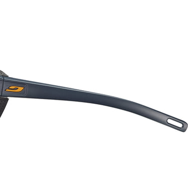 Close-up of the dark gray temple arms on Julbo USA's Camino Lenses & Parts, showing an orange logo near the hinge and a small elongated hole at the arm's end.