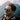 A man wearing Julbo Eyewear's Legacy RX with blue mirrored lenses and a jacket smiles outdoors with mountains in the background.