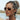 A woman in profile wearing round aviator-style sunglasses with a clear frame and warm brown mirrored lenses, photographed outdoors near water.
