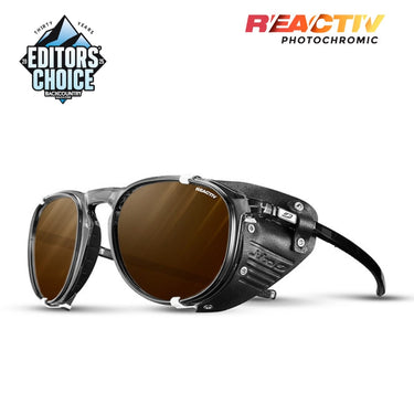 Julbo Eyewear’s Millenium sunglasses feature black lightweight frames, brown lenses, and side shields, with Editors Choice and Reactiv Photochromic logos shown on a white background. #color_translucent-white-with-reactiv-2-4-polarized-lens