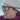 A person is smiling outdoors in the snow, wearing a beige knit beanie, a purple jacket, and Julbo-usa Spark dark sunglasses with photochromic lenses.