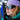 Wearing a purple hat and Julbo Eyewear Whoops sunglasses, a person stands by skis as snowy scenery reflects in their lenses.