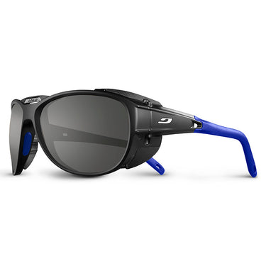 Julbo Eyewear's Explorer 2.0 RX sport sunglasses in black and blue, featuring REACTIV photochromic lenses, side shields, dark lenses, and wraparound temples for mountaineering, are shown on a white background. #color_black-/-blue