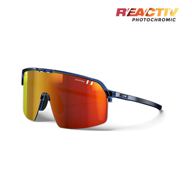 The Julbo Eyewear Intensity cycling sunglasses feature a blue frame and large red-orange mirrored photochromic lenses, ideal for trail running, displayed on a white background with "REACTIV PHOTOCHROMIC" text in the top right corner. #color_translucent-blue-black-with-reactiv-1-3-light-amplifier-lens