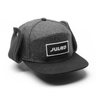 The Julbo Eyewear Woodsman Hat in gray and black features ear flaps for cold weather and a rectangular JULBO logo patch on the front, shown against a white background. #color_julbo-woodsman-hat-charcoal