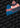 Two knit beanies with pom-poms, one blue and one gray, both with the word JULBO on the front, displayed on a background patterned with the word JULBO.