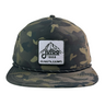 The Né dans les Alpes Unstructured Hat by Julbo Eyewear is a camouflage snapback featuring a mountain patch with coordinates, elevation, and "julbo 1888" on the front—perfect for adventure seekers. #color_né-dans-les-alpes-unstructured-hat-camo