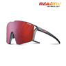 Julbo-usa Edge sunglasses feature a red mirrored single wraparound lens, black frame, REACTIV Technology branding on the top right, and an anti-fog coating for clear vision during intense rides. #color_translucent-black-matte-orange-with-reactiv-0-3-high-contrast-lens