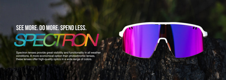 A pair of sports sunglasses with purple mirrored lenses sits on rocks; the text promotes Spectron lenses for visibility, functionality, and affordability in various weather conditions.