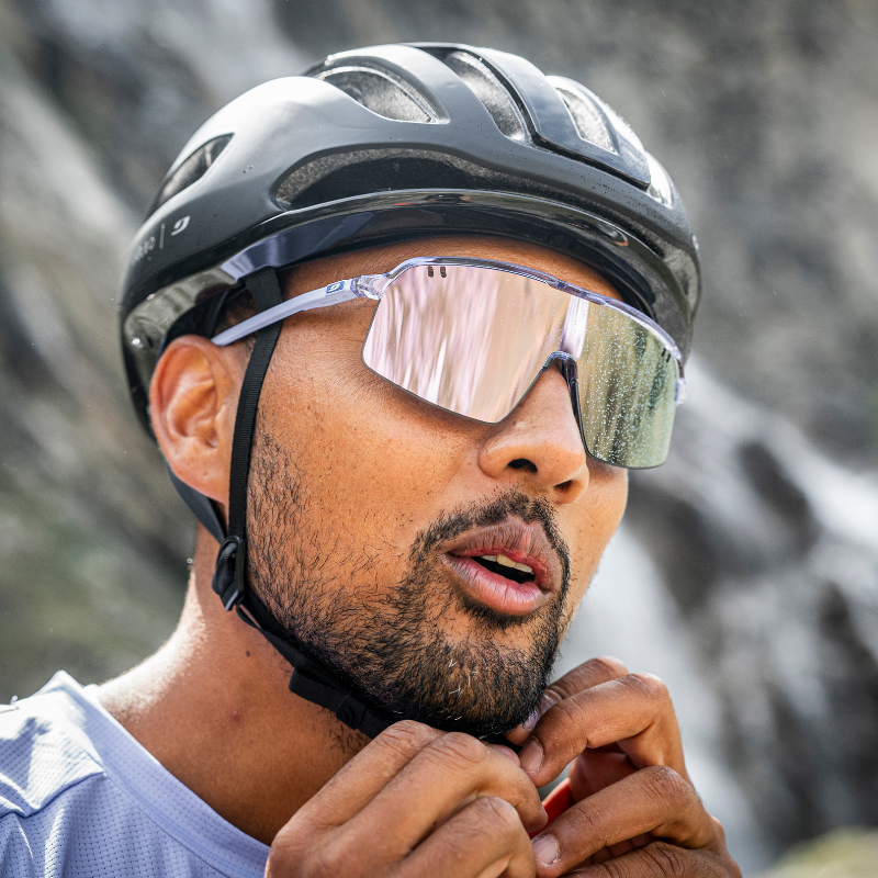 Cyclist wearing the Julbo Intensity sunglasses and buckling his helmet