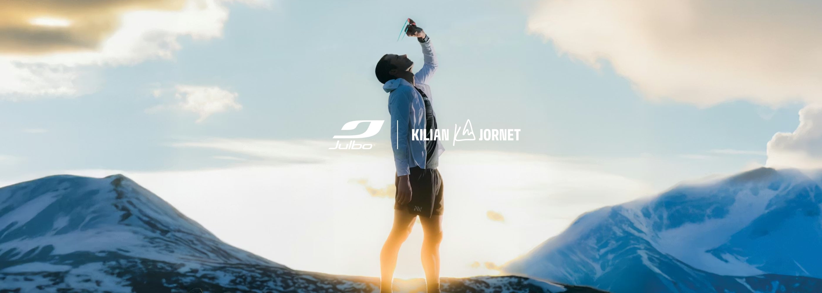 Photo of Julbo athlete Kilian Jornet looking through a pair of his signature sunglasses along with the Julbo logo and Kilian Jornet's logo.