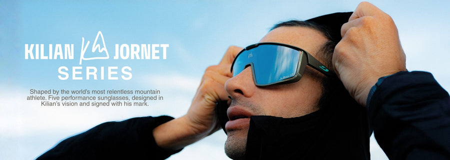 A person wearing sunglasses and a jacket adjusts their hood, with text promoting the Kilian Jornet Series performance sunglasses on the left side of the image.