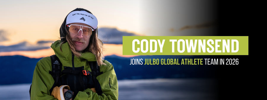 A man in winter gear stands outdoors at dusk with folded arms. Text reads: “Cody Townsend joins Julbo Global Athlete Team in 2026.”.