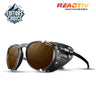 Julbo Eyewear’s Millenium sunglasses feature black lightweight frames, brown lenses, and side shields, with Editors Choice and Reactiv Photochromic logos shown on a white background. #color_translucent-white-with-reactiv-2-4-polarized-lens