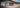 Sunglasses with brown-tinted lenses rest on a wooden surface next to a blurred bicycle tire. Text reads: Julbo RX FAQ. Youve got questions? Weve got answers.