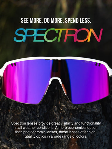 A pair of sports sunglasses with purple mirrored lenses sits on a rock, with promotional text about Spectron lenses above and below the image.