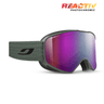 The Julbo-usa Cyclon ski goggles feature a wide, reflective purple lens, textured strap, helmet compatibility, and wide field of vision. The REACTIV PHOTOCHROMIC logo appears in the top right corner. #color_green-with-reactiv-0-4-high-contrast-lens