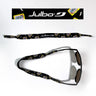 The Julbo Eyewear Neoprene Sunglass Strap is black with yellow cassette tape graphics, offers a waterproof, universal fit for secure comfort, and retro style. Shown both laid flat and attached to sunglasses. #color_julbo-neoprene-sunglass-strap-black-cassette-tapes