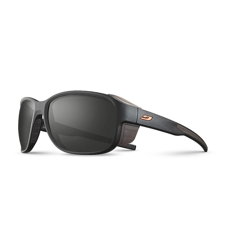 The Julbo Eyewear Montebianco 2.0 RX features matte black wraparound frames, dark lenses, side mesh vents, a small orange temple logo, and Spectron Rx polycarbonate lenses for extra durability. #color_black-/-orange
