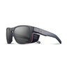 Julbo Eyewear's Shield M RX sports sunglasses feature a matte black frame with dark lenses, red accents, removable side shields, and a fabric temple strap. Compatible with REACTIV photochromic Rx lenses for custom prescriptions. #color_translucent-gray-/-pink