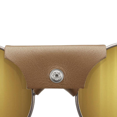 Close-up of Julbo USA's Vermont Lenses & Parts: sunglasses with yellow-tinted lenses, brown leather bridge cover with metallic button, and sleek temple arms inspired by Vermont Classic design. #color_vermont-nose-cover-brown