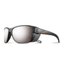 The Julbo-usa Camino features black wraparound frames with mirrored lenses, side shields, and an orange temple logo—perfect for trekking or outdoor adventures. #color_black-with-spectron-4-lens